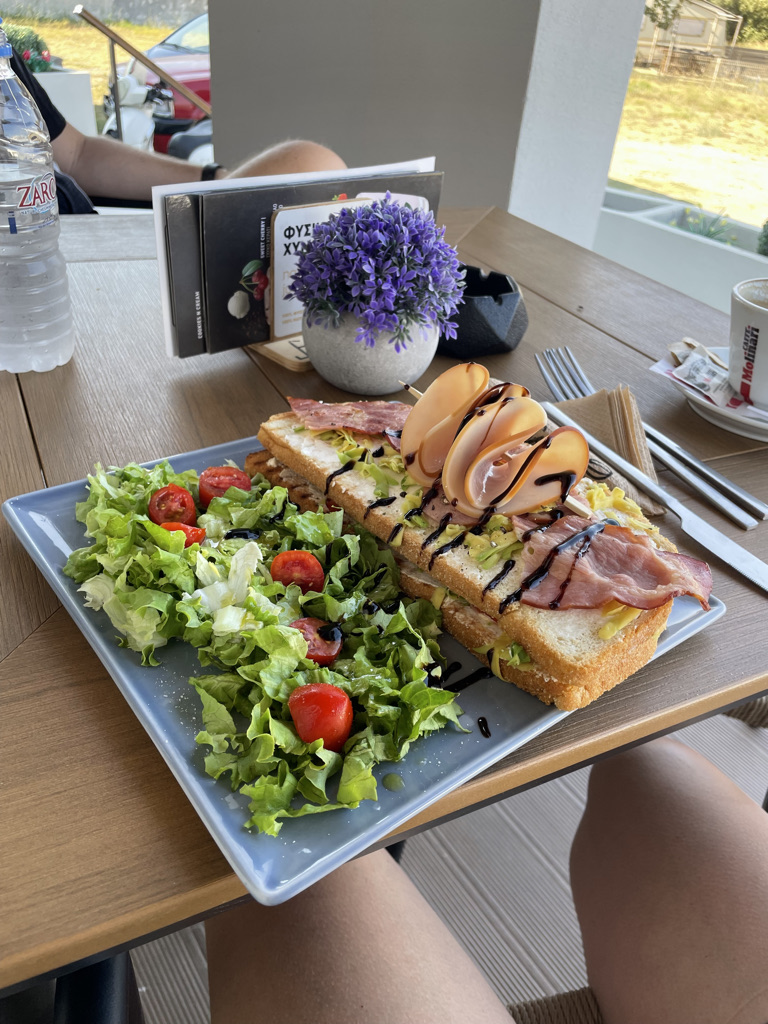 Photo of avocado toast sandwich with a salad on a bakery table.