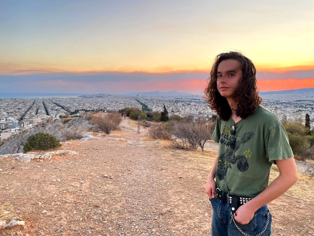 My son Felix standing on a hill with a view of Athens
