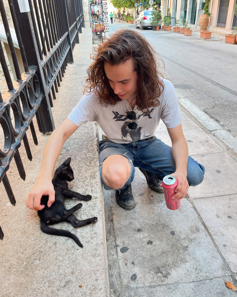 My son petting a tiny black kitten